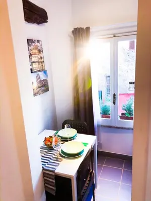 a small kitchen with a table with plates on it at Romantico appartamento a Trastevere in Rome