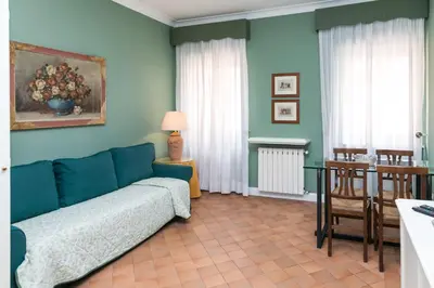 a living room with a blue couch and a table at Rasella Suites 47 in Rome