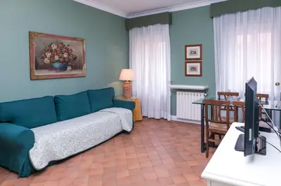 a living room with a blue couch and a table at Rasella Suites 47 in Rome