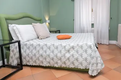 a bedroom with a bed with an orange pillow on it at Rasella Suites 47 in Rome
