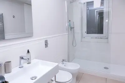 a white bathroom with a sink and a toilet at Rasella Suites 47 in Rome