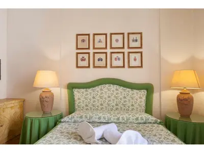 a bedroom with a green bed with two lamps at Rasella Suites 47 in Rome