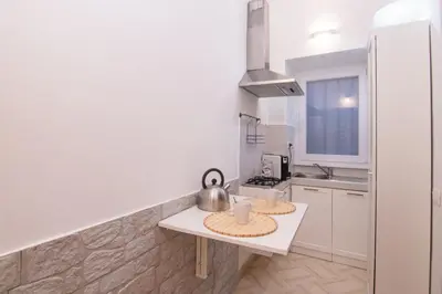 a white kitchen with a table and a sink at Deluxe Suite Welness in Rome