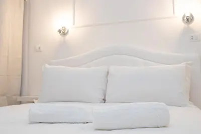a white bed with white pillows on it at Deluxe Suite Welness in Rome