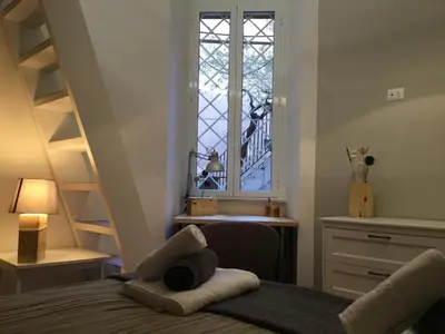 a bedroom with a bed with a window and a desk at LE FATE STUDIO a San Pietro in Rome