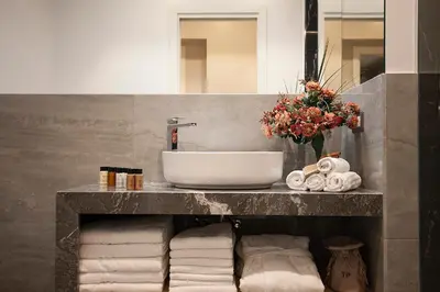 a bathroom with a sink and a vase of flowers at Roman Holidays Boutique in Rome