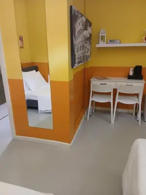 a room with a mirror and a bed and a desk at Stefano House Vaticano Roma in Rome