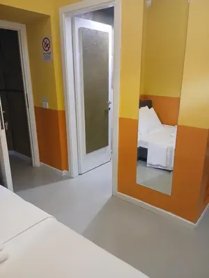 a room with a bed and a mirror and a door at Stefano House Vaticano Roma in Rome