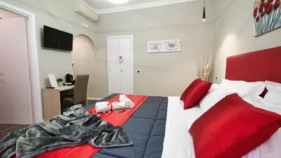 a bedroom with a large bed with red pillows at Home Suites Giolitti in Rome