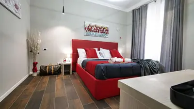 a bedroom with a red bed and a red couch at Home Suites Giolitti in Rome