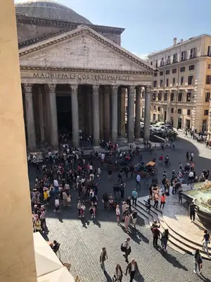a group of people walking around a fountain in a city at The Pantheon Eyes in Rome