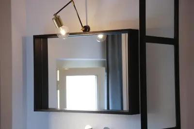 a mirror hanging on a wall with a light at Old Town Home Trastevere in Rome