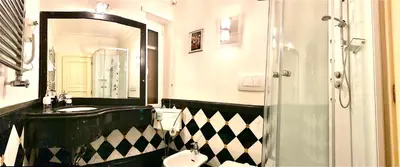 a black and white bathroom with a sink and a mirror at Simon's Guest House Rome in Rome