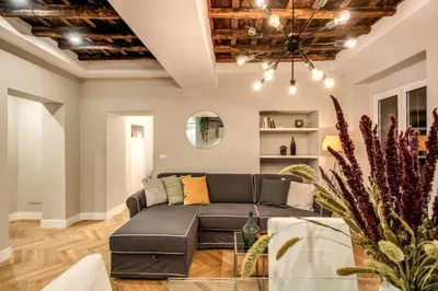 a living room with a couch and a chandelier at Trevi Fountain Superior 3 bdr apartment in Rome