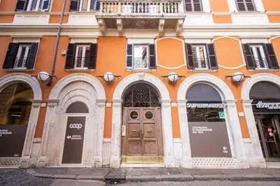 an orange building with a wooden door on a street at Trevi Fountain Superior 3 bdr apartment in Rome