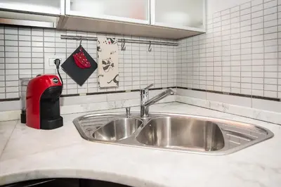 a kitchen counter with a sink and a fire extinguisher at Cosy Apartment 5 minutes from St Peter in Rome