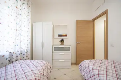 a bedroom with two beds and a dresser at Cosy Apartment 5 minutes from St Peter in Rome