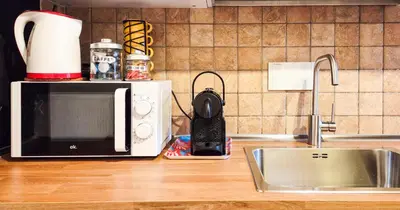 a kitchen counter with a microwave and a sink at Casa Flavia - Beauty apartment close to Vatican Museum in Rome