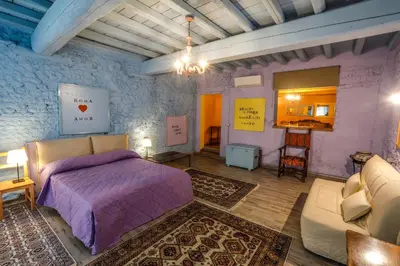 a bedroom with a purple bed and a couch at Rome old town luxury loft in Rome
