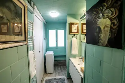 a green bathroom with a sink and a mirror at Rome old town luxury loft in Rome