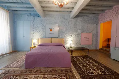 a bedroom with a purple bed and a rug at Rome old town luxury loft in Rome