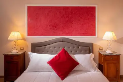 a bedroom with a red painting above a bed at Residenza Nobile Laurina in Rome