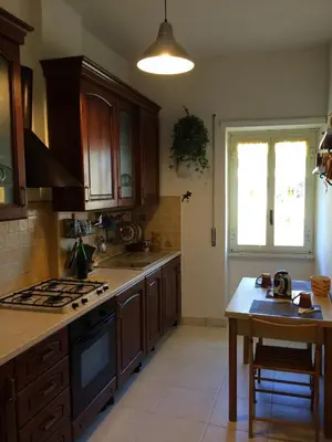 a kitchen with wooden cabinets and a table and a window at Casa Alberto in Rome