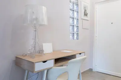 a desk with a lamp and two white chairs at Penthouse with Panoramic Terrace -3 Min to Metro A in Rome