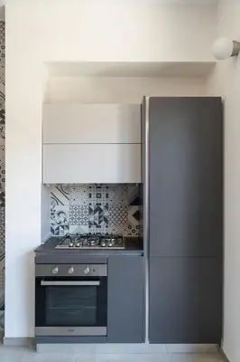 a kitchen with a stove and a refrigerator at Penthouse with Panoramic Terrace -3 Min to Metro A in Rome