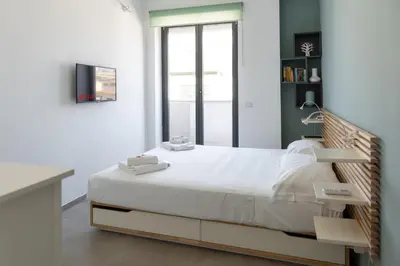 a bedroom with a bed with white sheets and a window at Penthouse with Panoramic Terrace -3 Min to Metro A in Rome