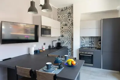 a kitchen with a table with a bowl of fruit on it at Penthouse with Panoramic Terrace -3 Min to Metro A in Rome