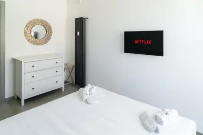 a bedroom with a bed with a tv on the wall at Penthouse with Panoramic Terrace -3 Min to Metro A in Rome