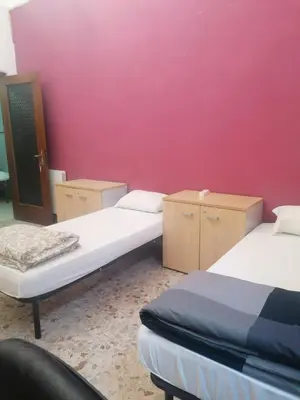 a room with two beds and a pink wall at Dream Destination Rome in Rome