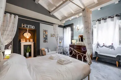a bedroom with a large bed and a room with a fireplace at Rome As You Feel - Torre Design Apartment in Rome