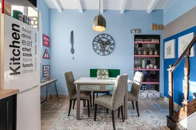 a dining room with blue walls and a table and chairs at Rome As You Feel - Torre Design Apartment in Rome