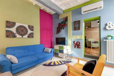 a living room with a blue couch and colorful walls at Rome As You Feel - Torre Design Apartment in Rome