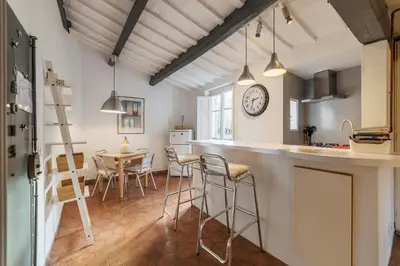 a kitchen and dining room with a clock on the wall at GuestHost - Charming Loft Navona in Rome