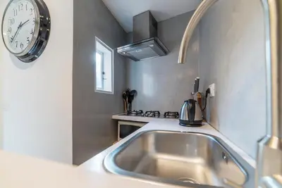 a kitchen with a sink and a clock on the wall at GuestHost - Charming Loft Navona in Rome