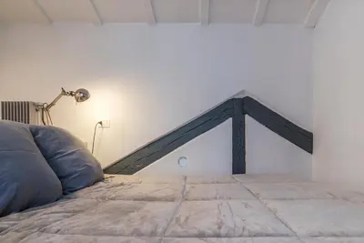 a bed in a room with a lamp next to a bed at GuestHost - Charming Loft Navona in Rome
