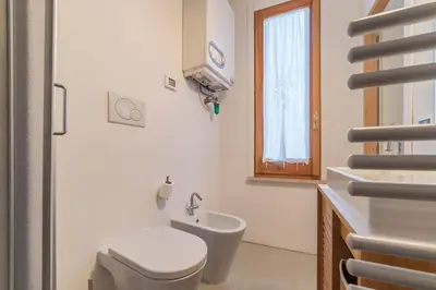 a white bathroom with a toilet and a sink at GuestHost - Charming Loft Navona in Rome