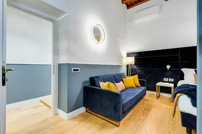 a blue couch in a room with a bed at Glamour Studio - Spanish Steps in Rome