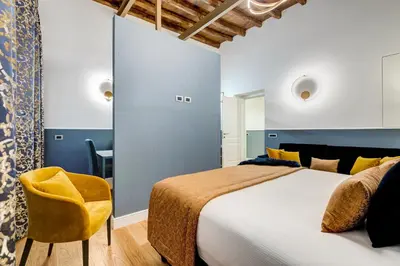 a bedroom with a large bed and a yellow chair at Glamour Studio - Spanish Steps in Rome