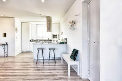 a kitchen with white walls and a counter and stools at St. Peter penthouse in Rome