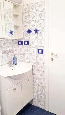 a white bathroom with a sink and a mirror at STEFY ROME APARTMENT in Rome