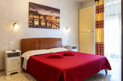a bedroom with a red bed with a red blanket at Bed and Breakfast La Stazione Del Vaticano in Rome