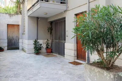 a building with doors and a tree in a courtyard at Bed and Breakfast La Stazione Del Vaticano in Rome
