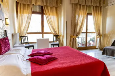 a bedroom with a large bed with a red blanket at Bed and Breakfast La Stazione Del Vaticano in Rome