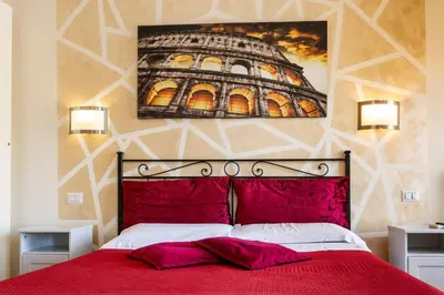 a bedroom with a red bed with a painting on the wall at Bed and Breakfast La Stazione Del Vaticano in Rome