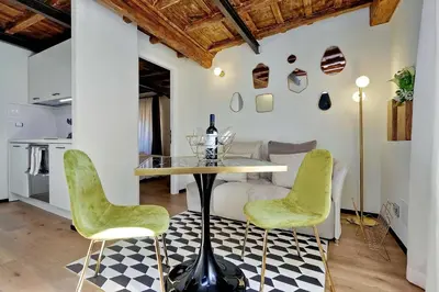 a dining room with a table and two green chairs at Restart Accommodations Rome in Rome
