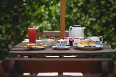 a wooden table with plates of food and drinks on it at Le Tare B&B in Rome
